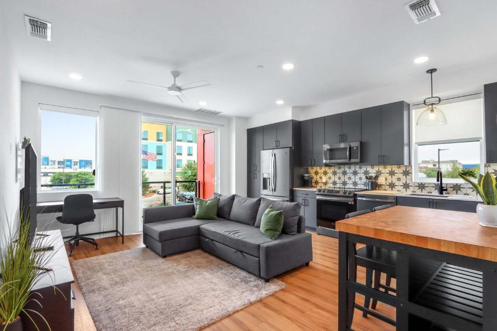 a living room with a couch and a kitchen at Creekside Modern - Condo for 4 in New Braunfels