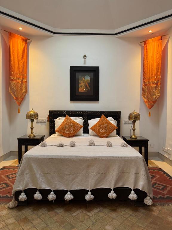 a bedroom with a bed with two tables and two windows at Riad Dar Balthazar in Marrakesh