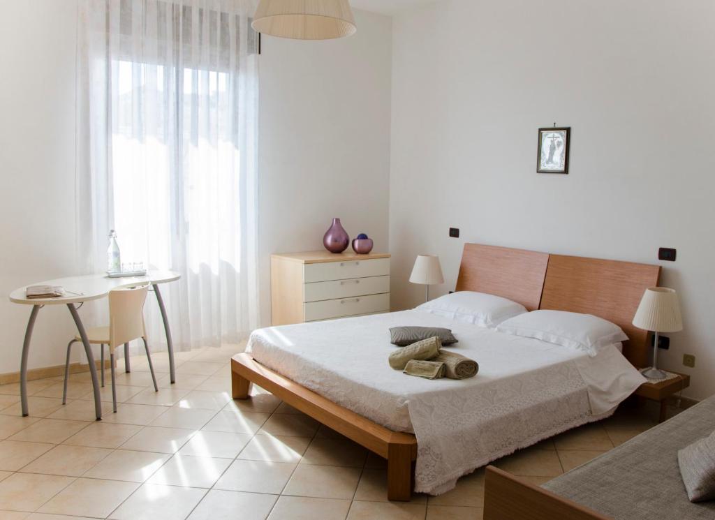 Dormitorio blanco con cama y mesa en B&B Ore Liete, en Martano