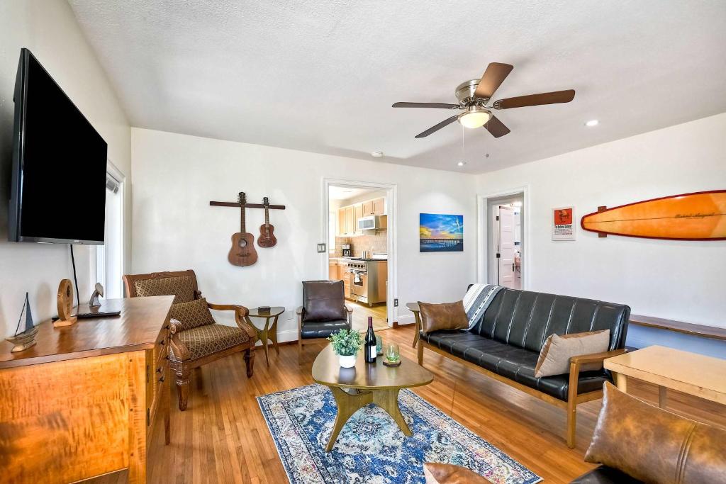 ein Wohnzimmer mit einem Sofa und einem Surfbrett an der Wand in der Unterkunft Vintage Beach Bungalow - For 6 in Oceanside