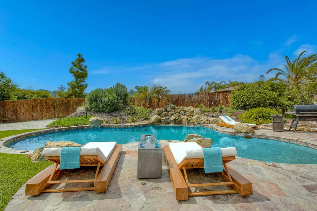 una piscina con 2 tumbonas en un patio trasero en O-side Oasis - Luxury Stay for 7, en Oceanside