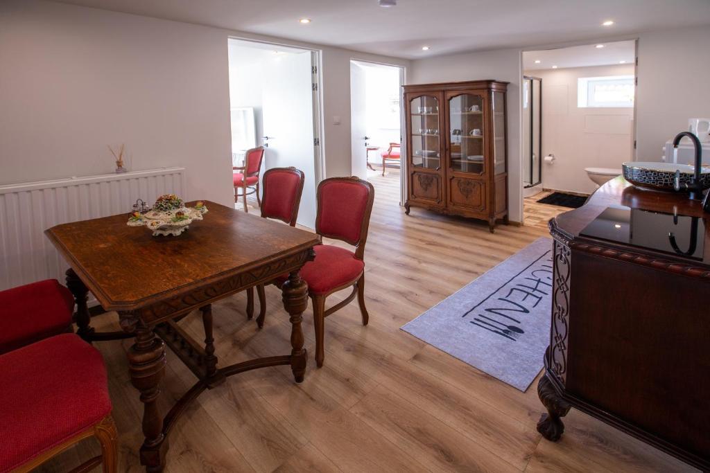 a living room with a wooden table and red chairs at Apartman louis A102 in Tomášikovo