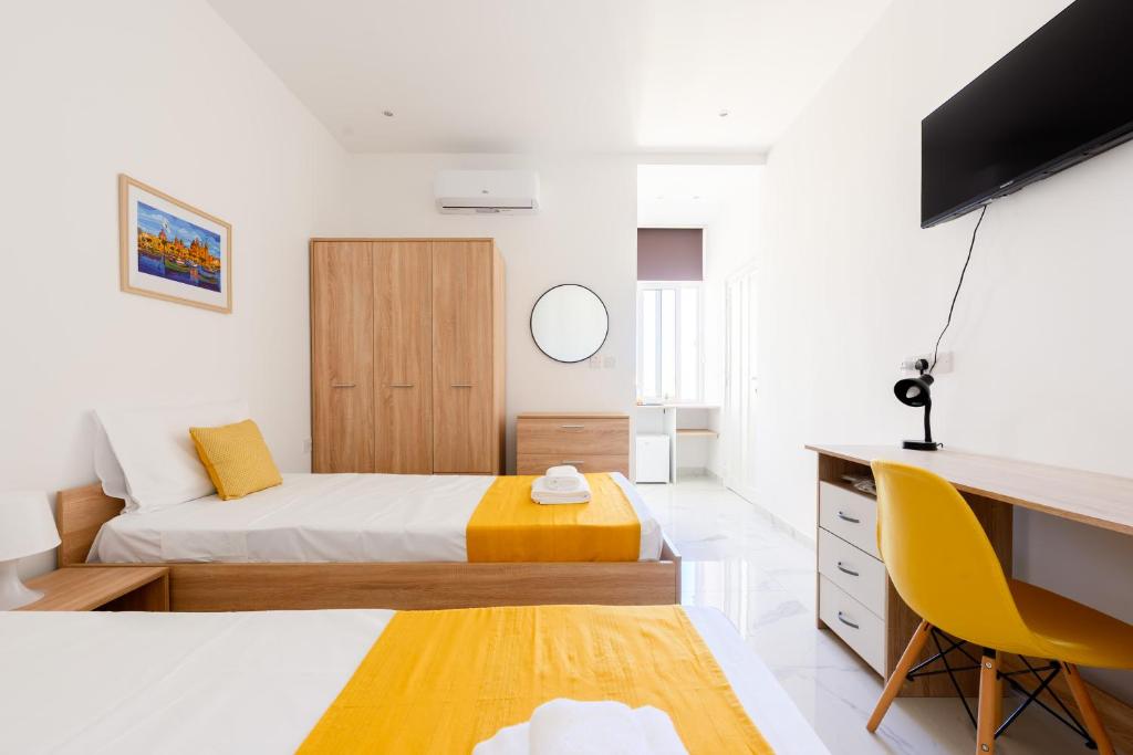 a bedroom with a bed and a desk and a television at F8-4 Sliema ensuite bedroom in Sliema