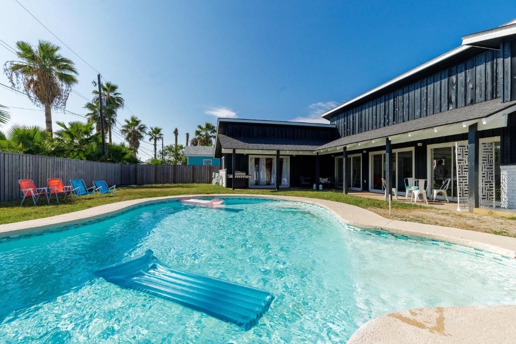 a swimming pool in front of a house at Stylish 3 bedroom - Pool Pets Sleeps 10 in Port Aransas