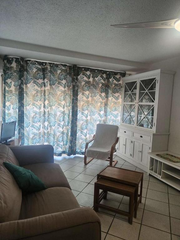 un salon avec un canapé et une chaise dans l'établissement Résidence Palmyra - Appartement 2 pièces 4 couchages LE BARCARES MAE-5754, au Barcarès
