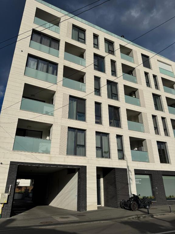a large white building with a motorcycle parked in front at MA Housing - Central Apartment in Cluj-Napoca