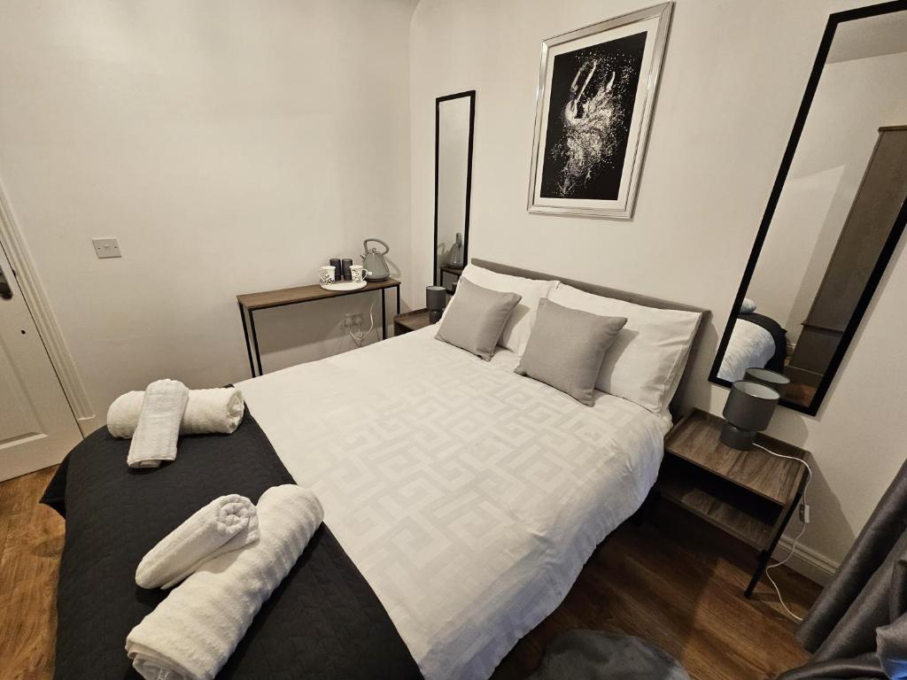 a bedroom with a large white bed with towels on it at Apartment Royston Center in Royston