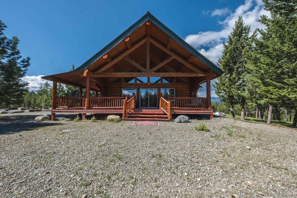 a log cabin with two benches in a yard at Maggies Cabin - Enjoy a Slice of Paradise in Rexford Montana in Rexford