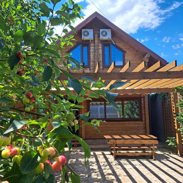 a wooden cabin with a bench in front of it at Domik u morya in Gribovka