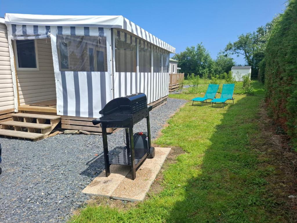 una barbacoa frente a una casa pequeña en Mobil-home bord de mer, en Colleville-sur-Mer