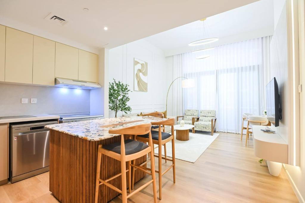 迪拜GV Holiday Homes DXB - Cozy 2BR Apartment in Town Square Dubai的配有桌椅的厨房和客厅