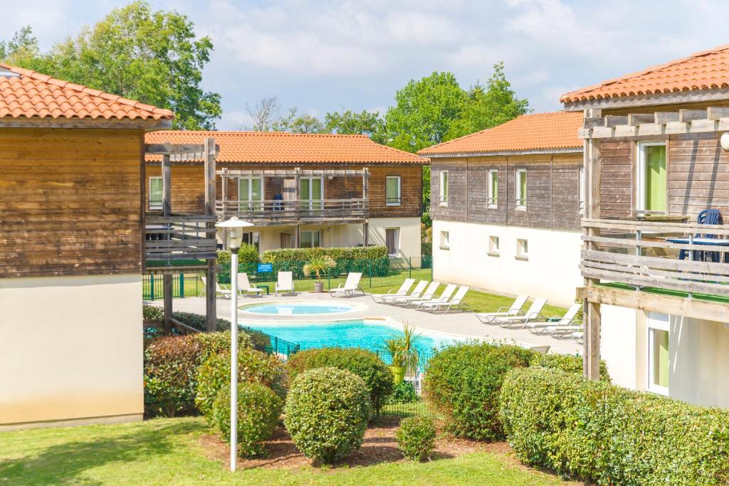 une cour avec une piscine et quelques bâtiments dans l'établissement Lagrange Vacances Les Terrasses du Lac, à Aureilhan