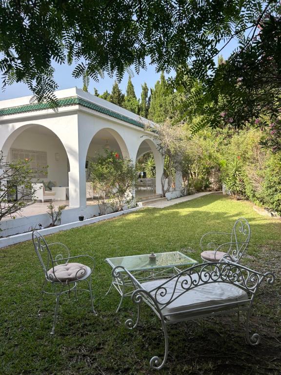 two chairs and a table in the yard of a house at Villa Mer in Nabeul