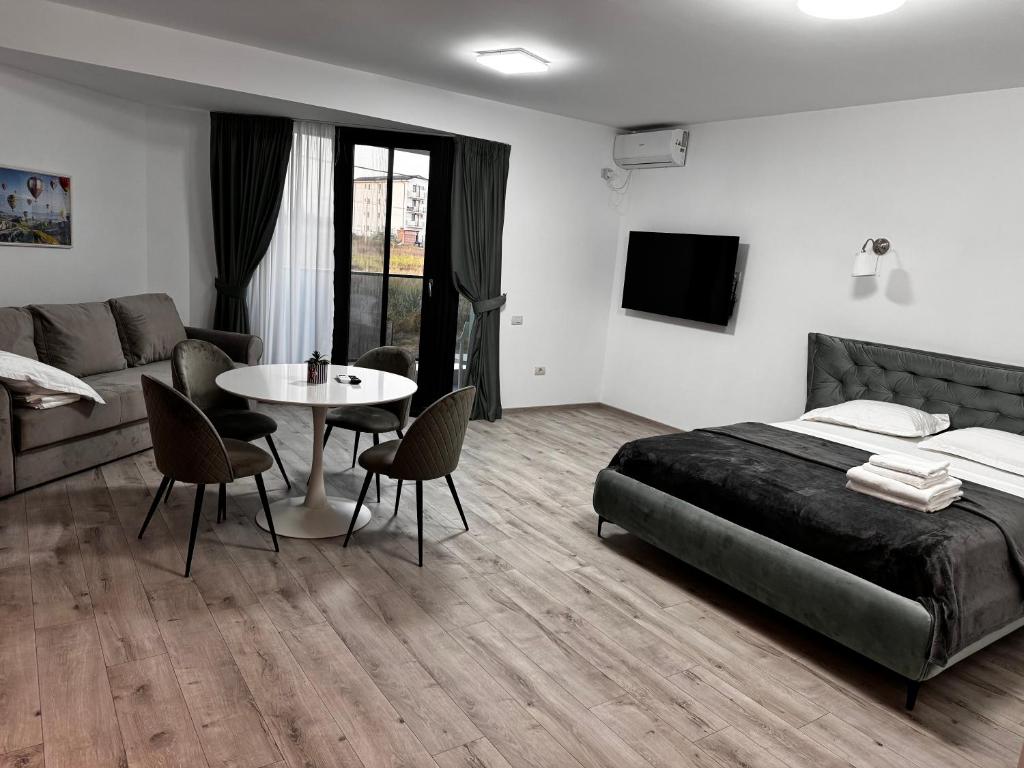 ein Schlafzimmer mit einem Bett, einem Tisch und einer Couch in der Unterkunft Twin Waves in Costinești