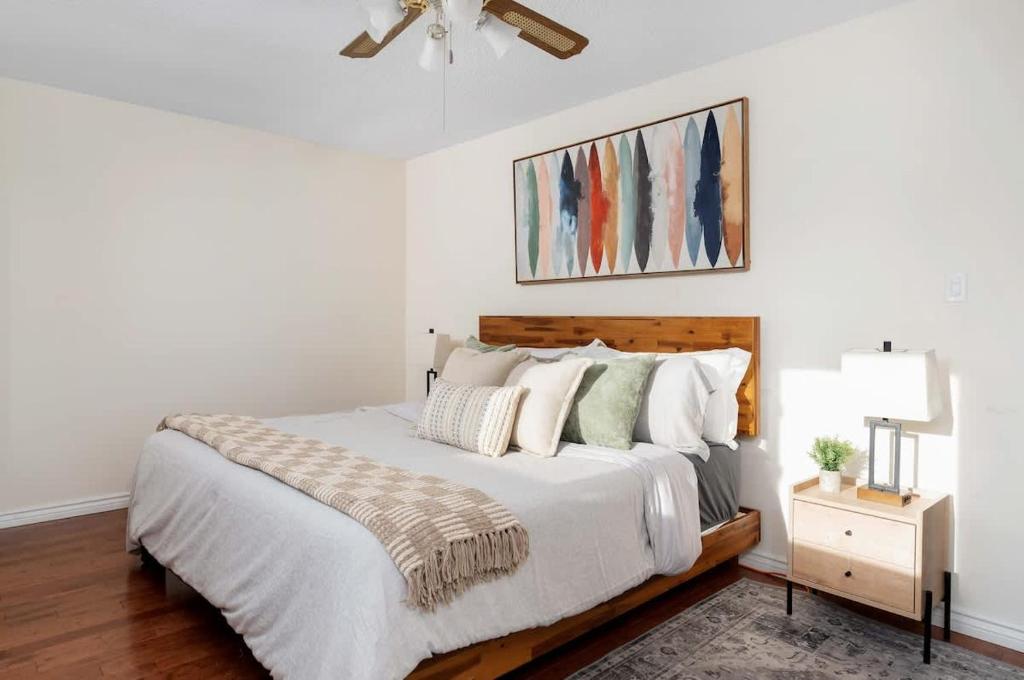a bedroom with a bed with white sheets and pillows at Huge 4 Bedroom House Near Square One - Sleeps 8 in Mississauga