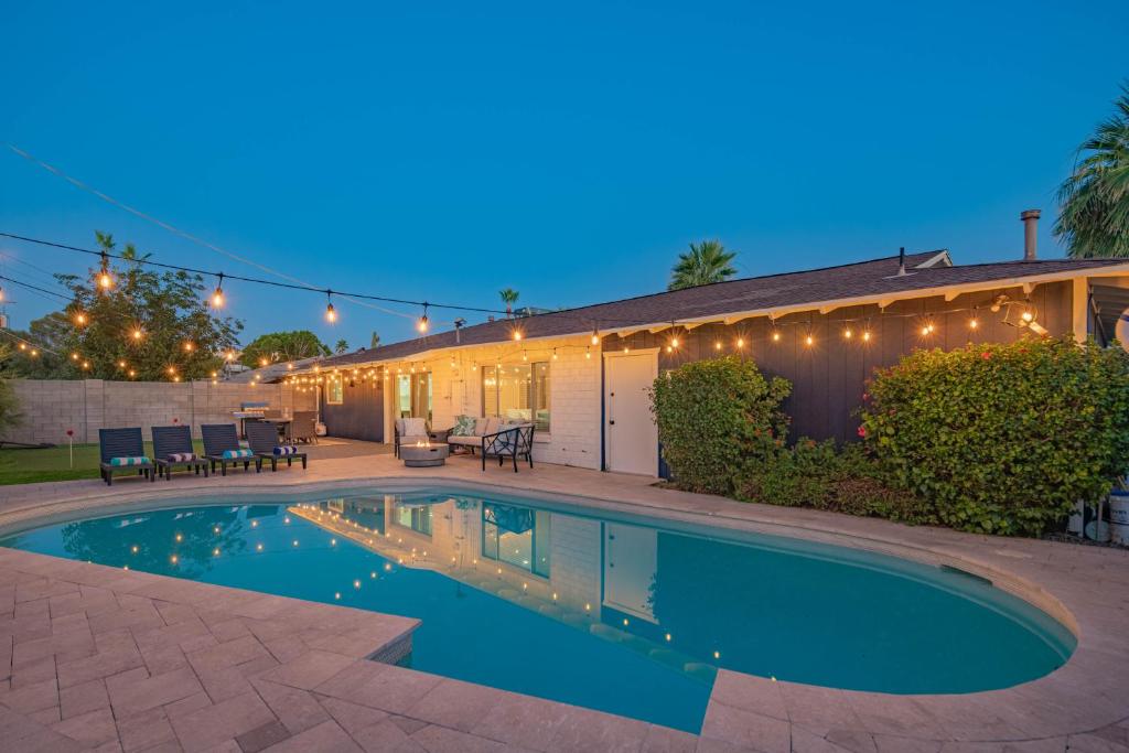Una piscina frente a una casa con luces. en Spacious 4BD with Pool and Putting Green Near Old Town Scottsdale, en Scottsdale