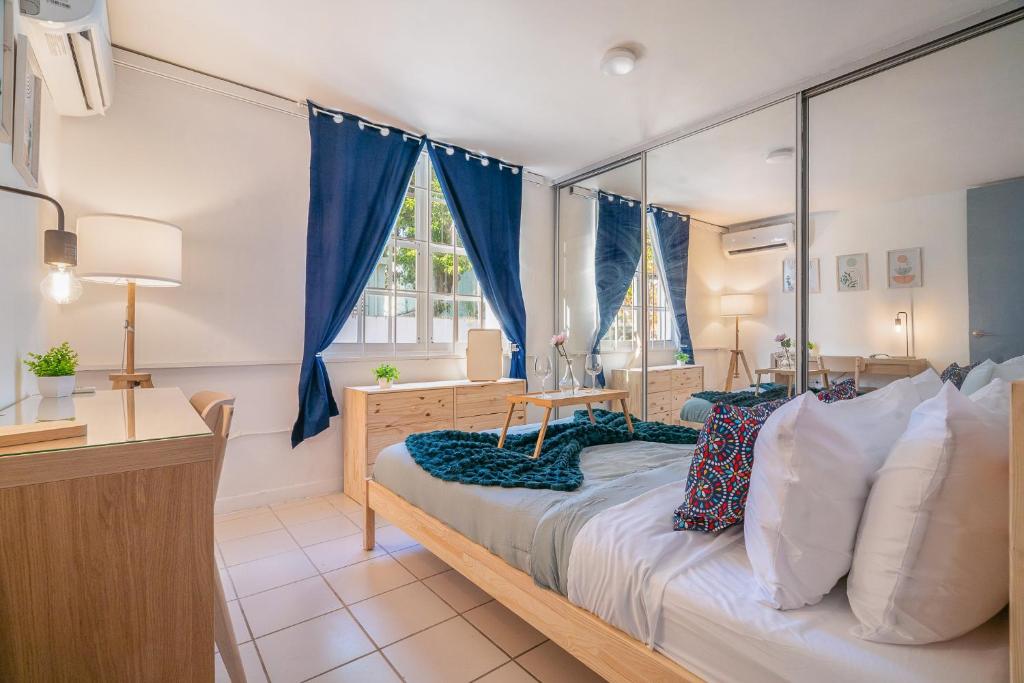 a bedroom with a large bed with blue curtains at Condado Home - Private Back yard by PH in San Juan