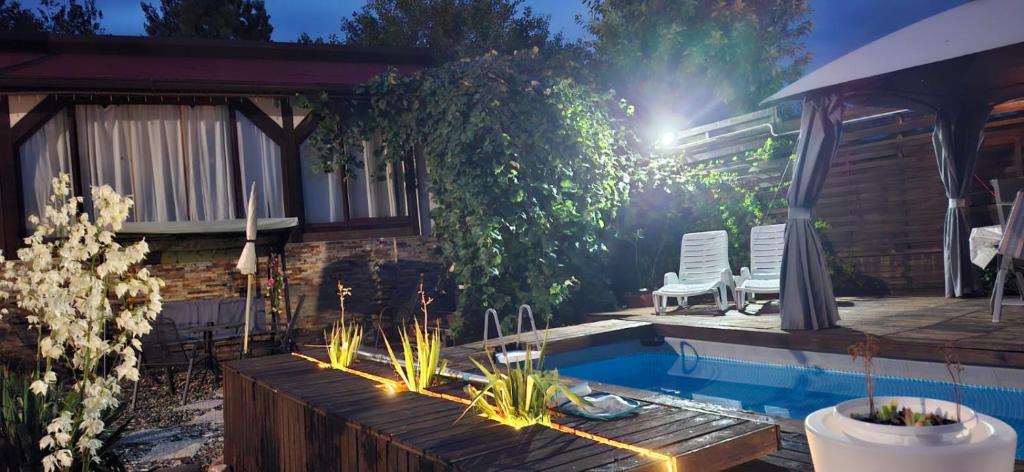 a backyard with a swimming pool and two lawn chairs at Apartment Casa Sarajevo in Sarajevo