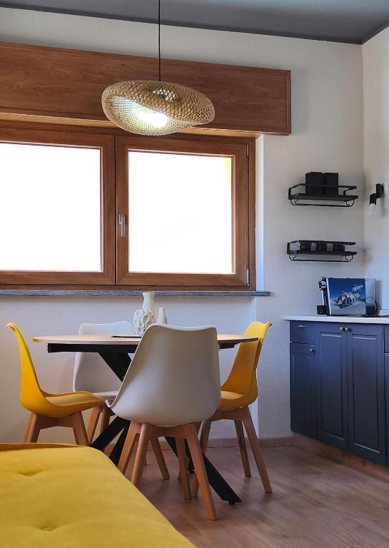 a dining room with a table and yellow chairs at Villa Rosina in Saint Vincent