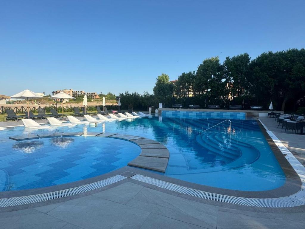 a large swimming pool with lounge chairs around it at Oasis Beach Lozenets 1 bed in Lozenets