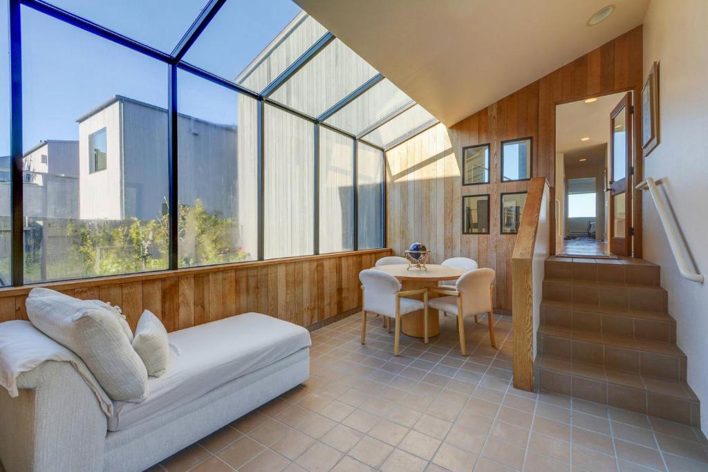 a room with a couch and a table and windows at Neel Nirvana - Deck With BBQ & Community Pool in Sea Ranch