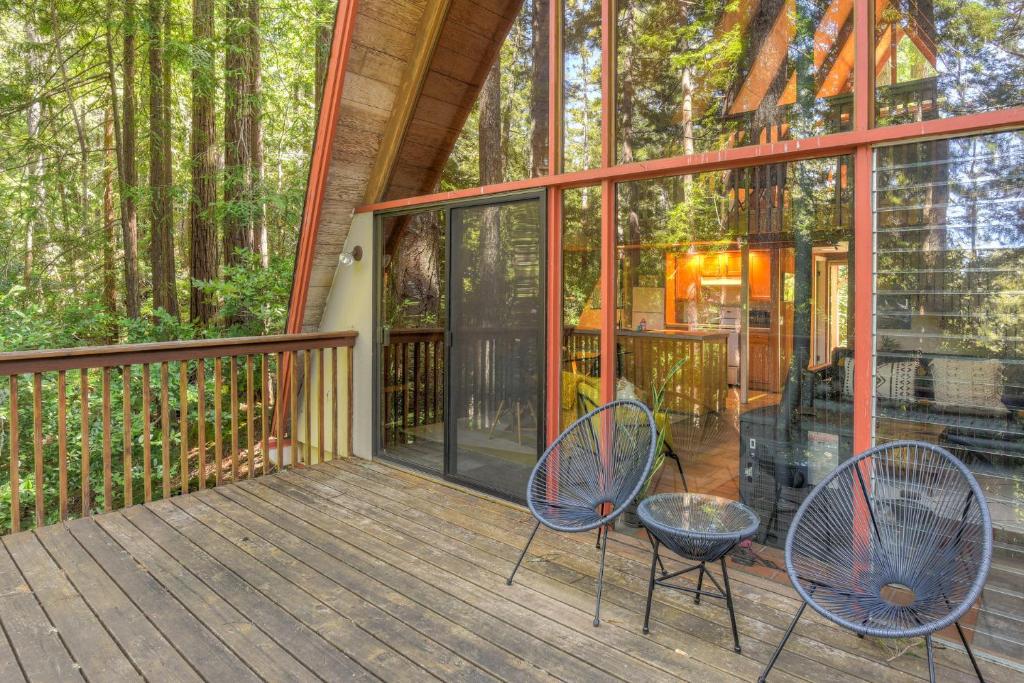 a screened in porch with two chairs and a table at Star Nest - Secluded Forest Property in Gualala