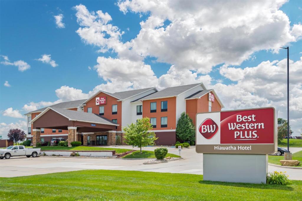 a best western plus sign in front of a building at Best Western Plus Hiawatha Hotel in Hiawatha