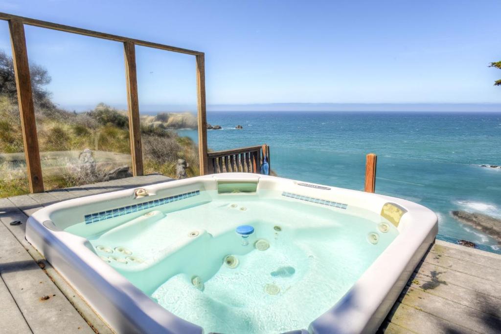 a hot tub with the ocean in the background at Haven's View With Stunning Ocean Views in Gualala
