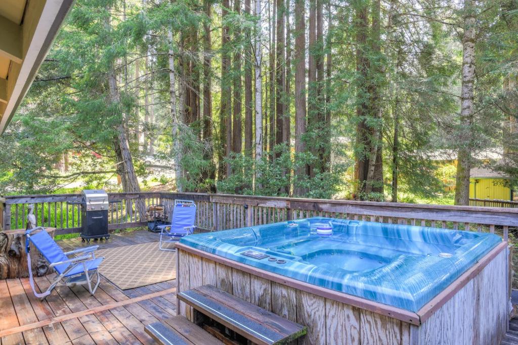 a hot tub on a deck with chairs and a grill at Searenity by the Sea - Private Hot Tub in Gualala