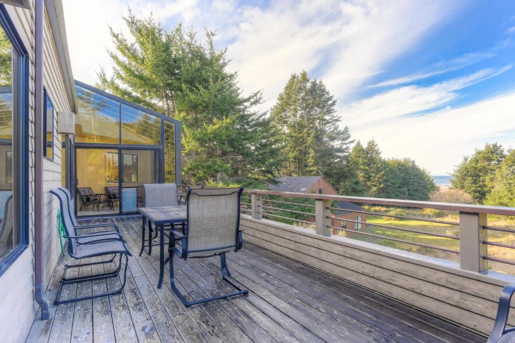 a deck with a table and chairs on it at Riverview - Private Hot Tub - Sleeps 12 in Sea Ranch