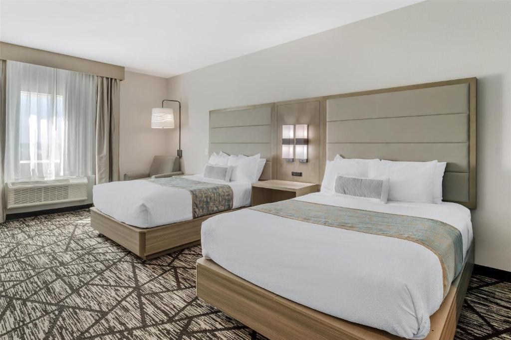 a hotel room with two beds and a large window at Best Western Plus Mid County in Port Arthur