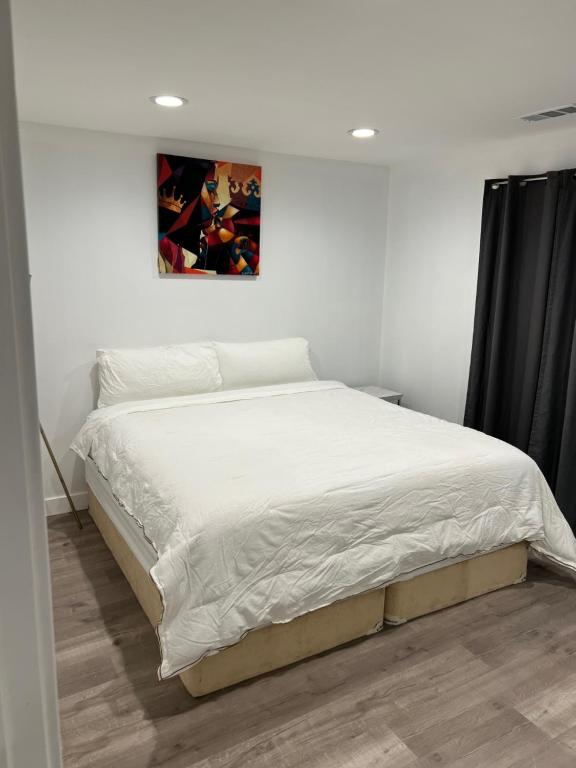 a bed in a bedroom with a picture on the wall at Brand new private one bed one bath home with private parking for 2 in Van Nuys Airport