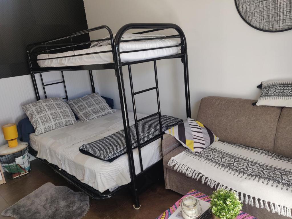a room with two bunk beds and a couch at Studio chaleureux sans-visà-vis in Vernon