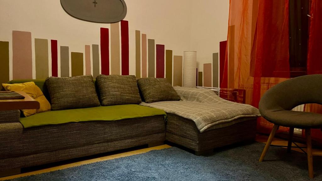 a couch in a living room with a colorful wall at Kawalerka Oaza Mnicha in Gdańsk