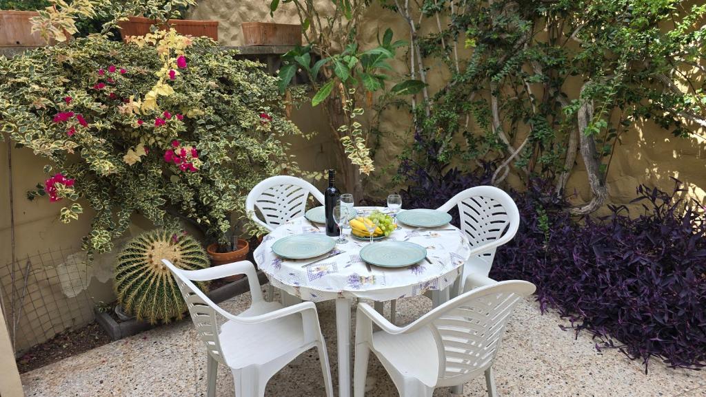 a white table with four chairs and flowers at nos appartements ciel et mer a tenerife in Puerto de la Cruz