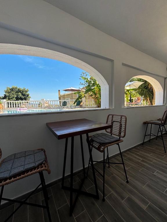 a table and chairs in a room with a window at Kalami Bay Apartment in Kalami