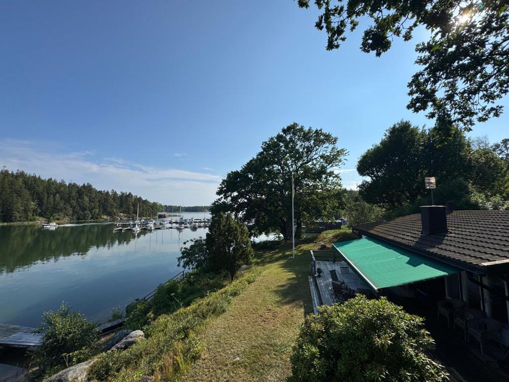 オーケシュバーリアにあるBeach house Nyborg - By Stockholm archipelagoの湖のそばにボートが浮かぶ家
