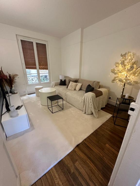 a living room with a couch and a table at Sublime appartement cosy près de la Tour Eiffel in Paris