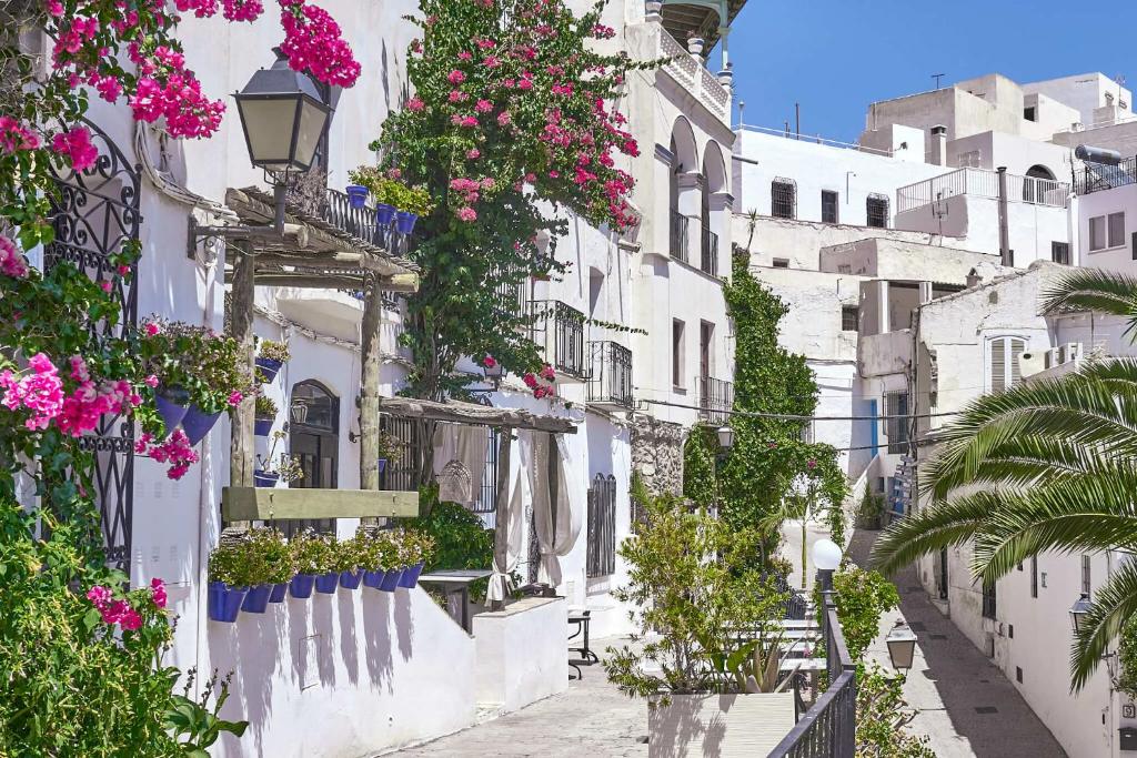 a street with flowers on the side of a building at Casa Walt in Mojácar