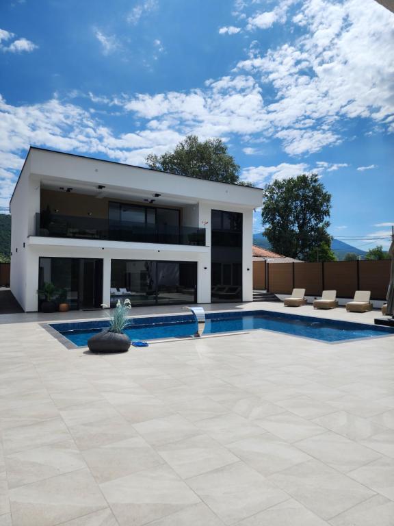ein Haus mit einem Swimmingpool davor in der Unterkunft La Villa Luxury Home Bihac in Bihać