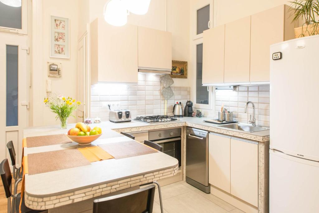 ブダペストにあるAPI Flatのキッチン(白いキャビネット付)、カウンターにフルーツを用意しています。