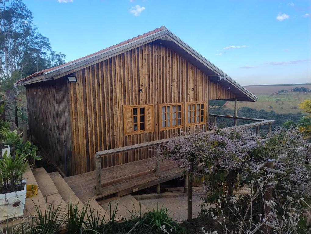 a wooden house with a bench in front of it at Casa de Madeira para Alugar em São Roque de Minas! in São Roque de Minas