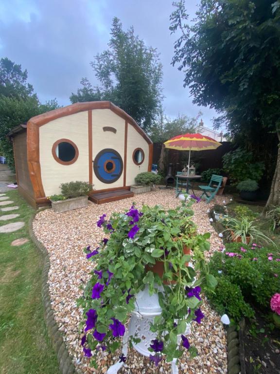 a bird house with flowers in a garden at Tyluna Cornish Glamping Cabin in Praze an Beeble