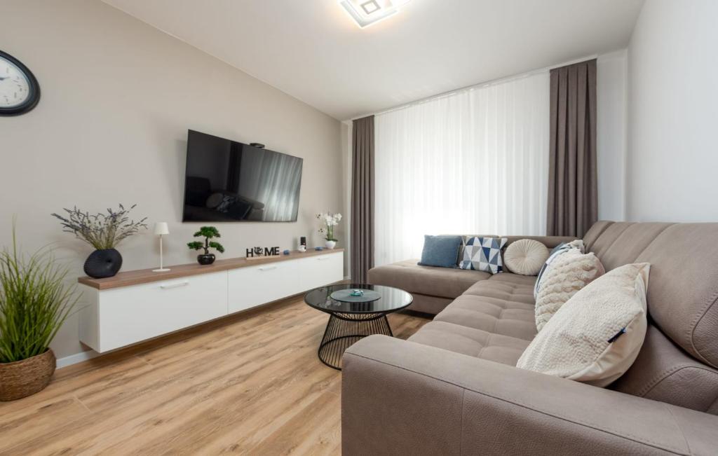 a living room with a couch and a tv at Luxe Holiday Home in Posedarje