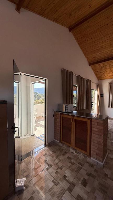 a kitchen with a counter and a sliding glass door at Recanto da Paz - Monte Verde in Monte Verde