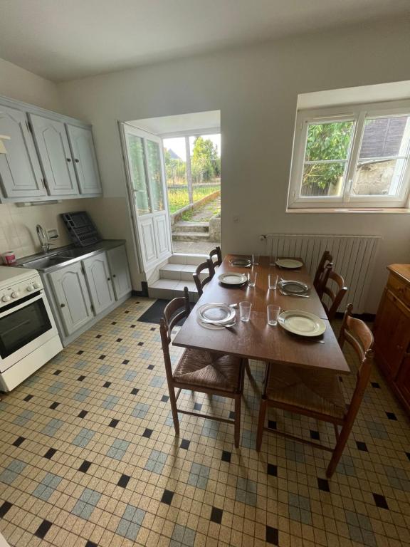 una cucina con tavolo in legno, sedie, tavolo e tavolo di Gite proche Chateau-gontier a Marigné-Peuton