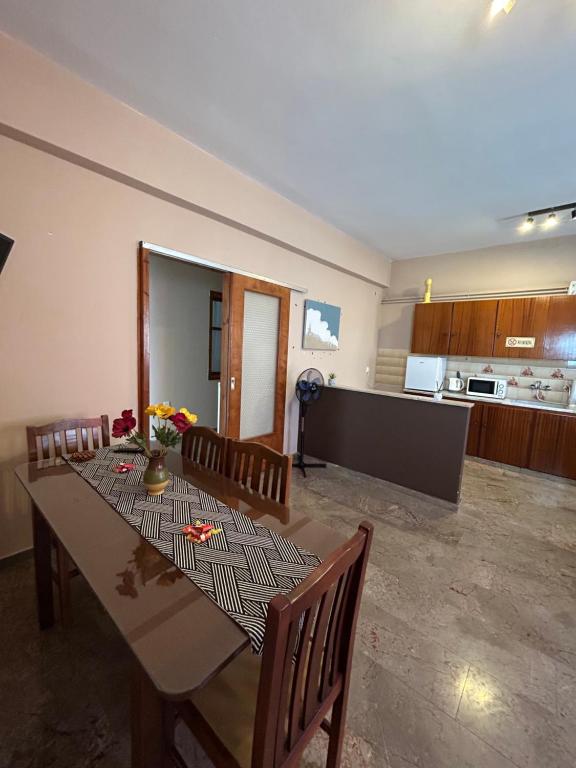 a dining room with a table and chairs and a kitchen at Authentic Village Stay in Kondodhespótion