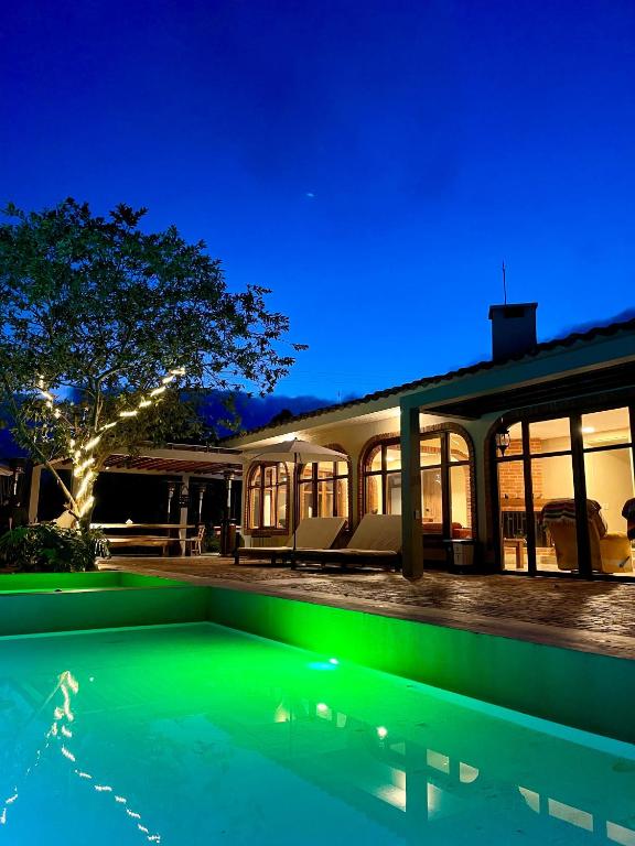 a house with a swimming pool at night at Hotel Campestre Rancho La Lechería in Cali