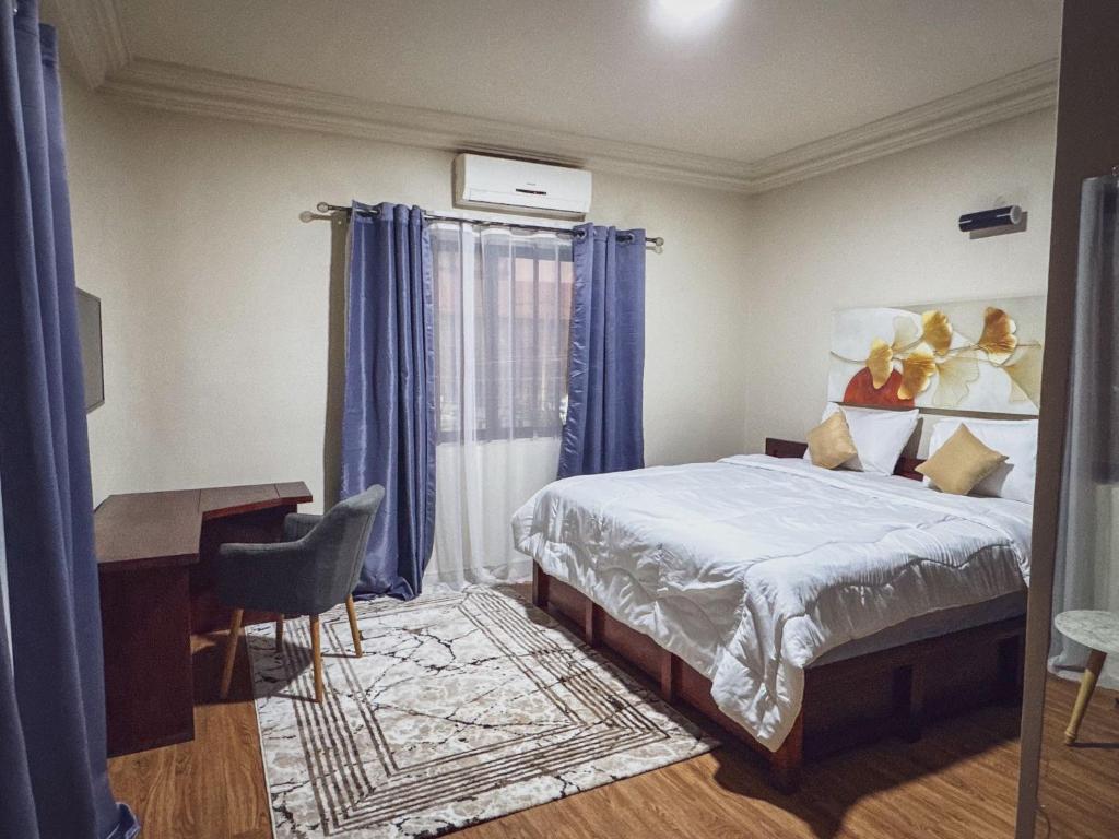 科托努Acropole Hotel的一间卧室配有一张床、一张书桌和一张书桌