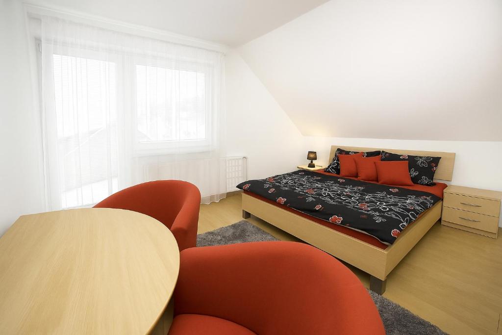 a bedroom with a bed and a table and chairs at Apartmánový dom Adriana in Zuberec